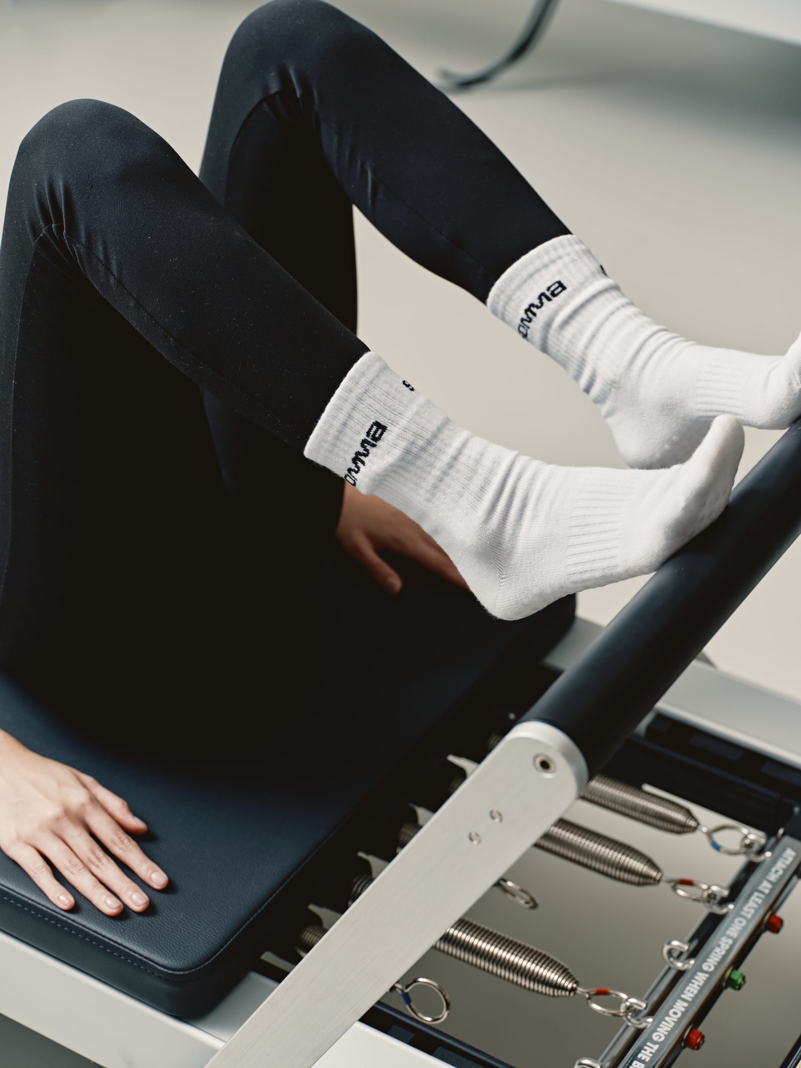 Feet in white Somma socks on a reformer carriage