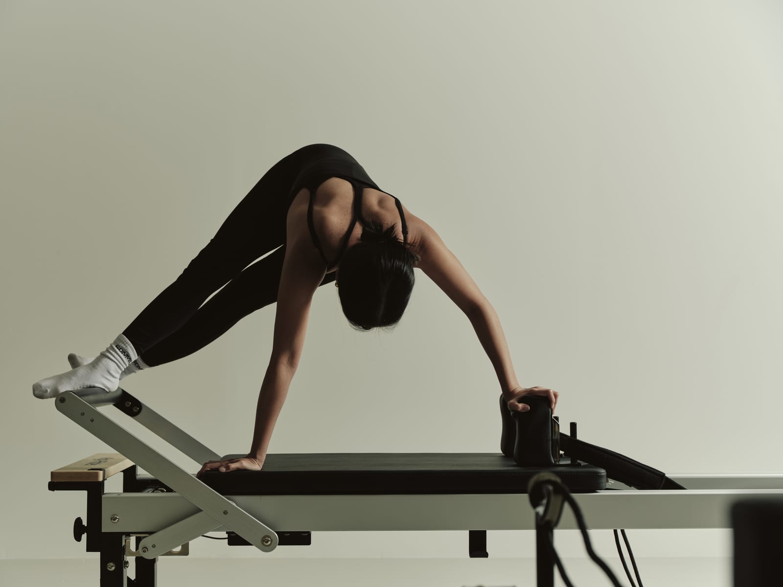 Client holding a plank variation on a Pilates reformer